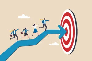Illustration of business professionals walking along a large blue arrow toward a red target, symbolizing teamwork, strategy, and goal achievement.