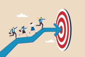 Illustration of business professionals walking along a large blue arrow toward a red target, symbolizing teamwork, strategy, and goal achievement.