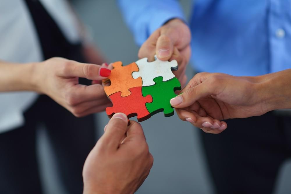 Group of business people assembling jigsaw puzzle